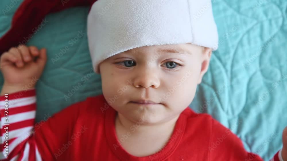 Portrait of Caucasian little boy in Santa Claus hat. Christmas, New Year and winter holidays celebration concept. First Christmas. Portrait of Caucasian little boy in Santa Claus hat. Christmas, New Year and winter holidays celebration concept. First Christmas.