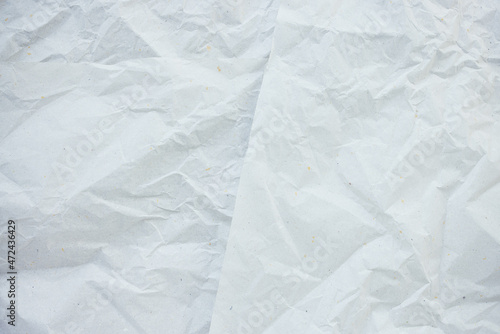 Crumpled white with color dots paper for gift wrapping or packaging. Closeup, texture background, pollution and recycling concept