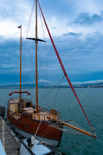 The city of Gelendzhik Russia, the Black Sea and a beautiful yacht with the name Pharaoh on a blue sky background.