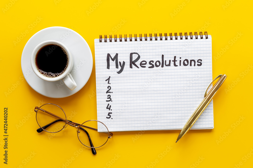 New Year resolution hand writing list - text on notepad, top view New Year resolution hand writing list - text on notepad, top view