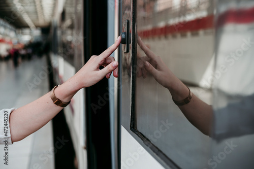 Young woman pressing button on train at railroad station photo