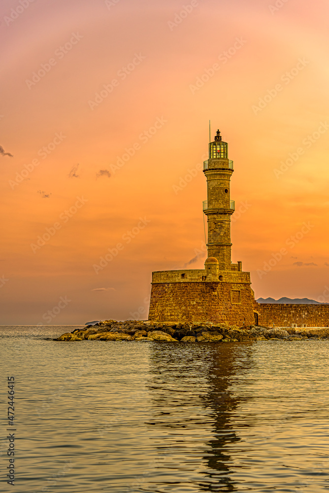 the lighthouse in the harbour of Chania glowing in the sunrise