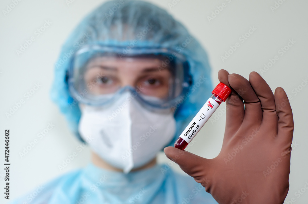 Medical laboratory assistant holding test tube with positive Omicron COVID-19 test blood sample. Medical laboratory assistant holding test tube with positive Omicron COVID-19 test blood sample.