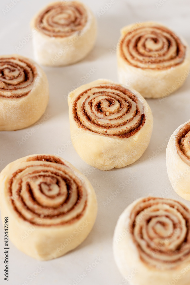 Cinnamon rolls homemade raw dough preparation. Cinnabons traditional dessert buns. Cinnamon rolls homemade raw dough preparation. Cinnabons traditional dessert buns.
