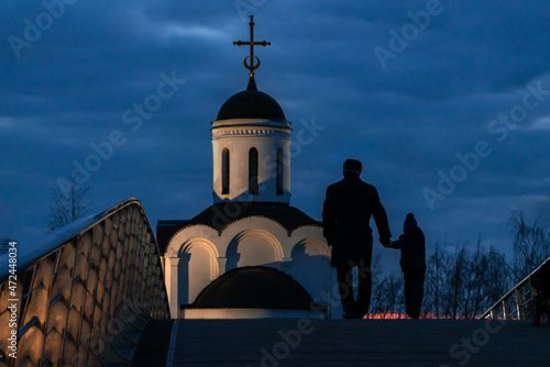 a man and a child go to church. silhouettes