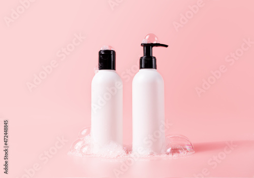 Shampoo and hair conditioner bottle with soapy bubbles. Plastic white packing with black cap beauty hair care cosmetic packaging mockup