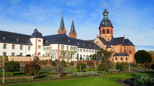 malerische Basilika und Kloster in Seligenstadt am Main mit gepflegtem Klostergarten unter blauem Himmel