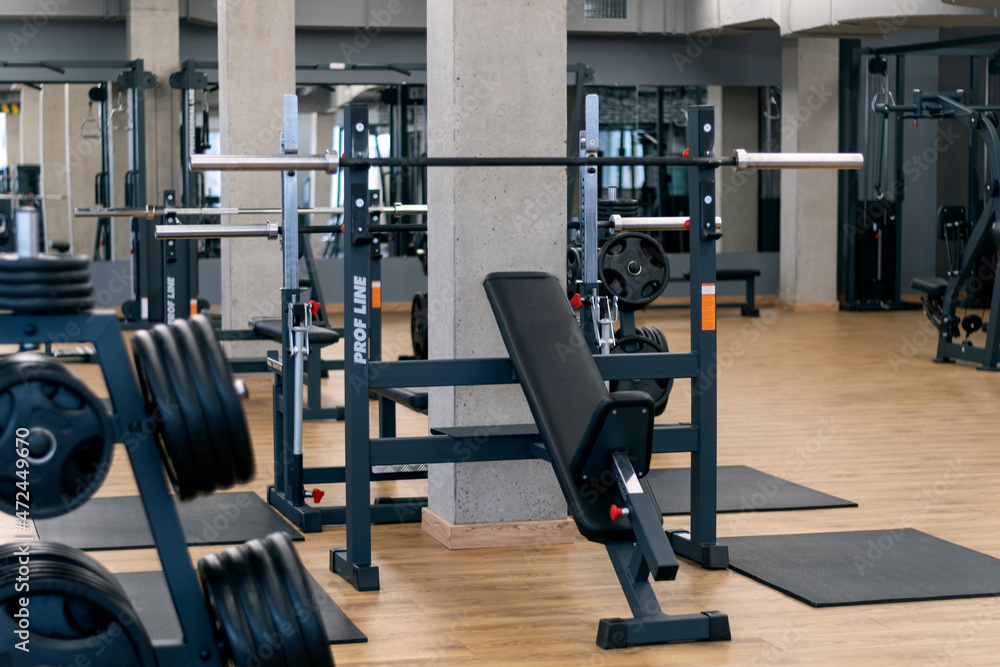 Modern gym with various equipment for training. Sports simulators and dumbbells.