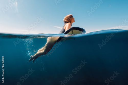 Sporty surfing girl in bikini with surfboard, split view