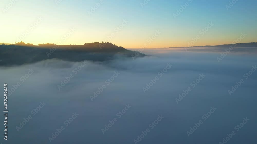 4K Drone Flying through the clouds at dusk or dawn. Aerial top cloudscape view from drone. Tropical forest with smoke and fog.
