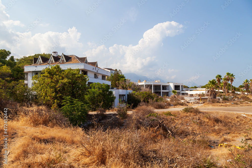 Abandoned building exterior view of Hotel in the Turkish village of kemer with broken windows and overgrown plants