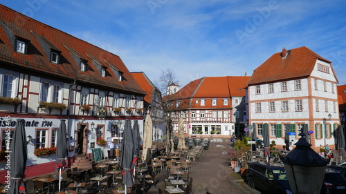 schöner Platz mit Biergarten in Seligenstadt zwischen malerischen Fachwerkhäusern unter blauem Himmel