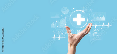 Businessman hold virtual plus medical network connection icons. Covid-19 pandemic develop people awareness and spread attention on their healthcare.Doctor,document,medicine,ambulance,patient icon.