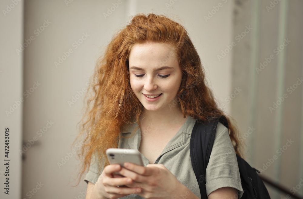 Fototapeta premium young woman in school uses smartphone