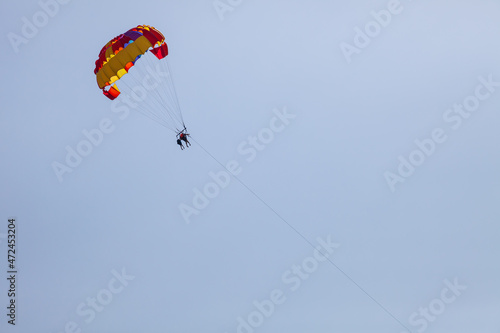 Tourists fly over the sea and the beach on a parachute. Sport and recreation for tourists in turkey
