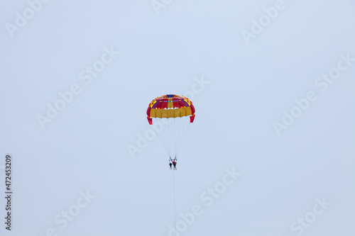 Tourists fly over the sea and the beach on a parachute. Sport and recreation for tourists in turkey