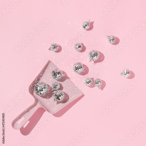 New Year party creative layout with  dico balls christmas decoration in dustpan on pastel pink background. 80s or 90s retro fashion aesthetic concept. New Year celebration idea. photo