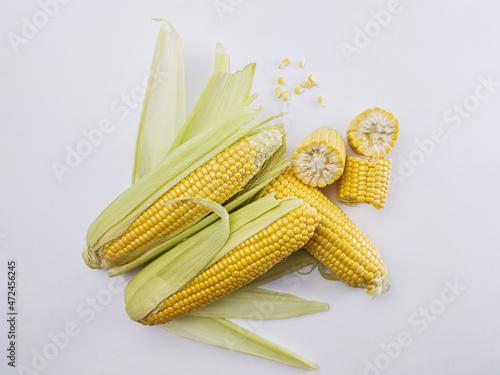 Fresh sweet corn on cobs on white background, closeup, top view