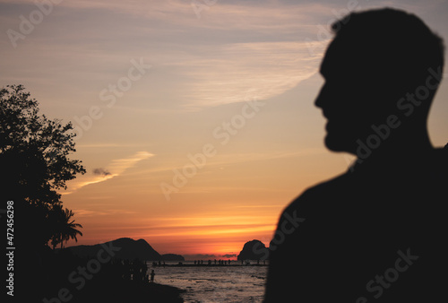 Silhouette of people watching sunset on Philippines island, El Nido. Scenic evening landscape on sunset. Tropical coast in night dusk. Amazing twilight at seaside.Tropical tourism. Evening mood.