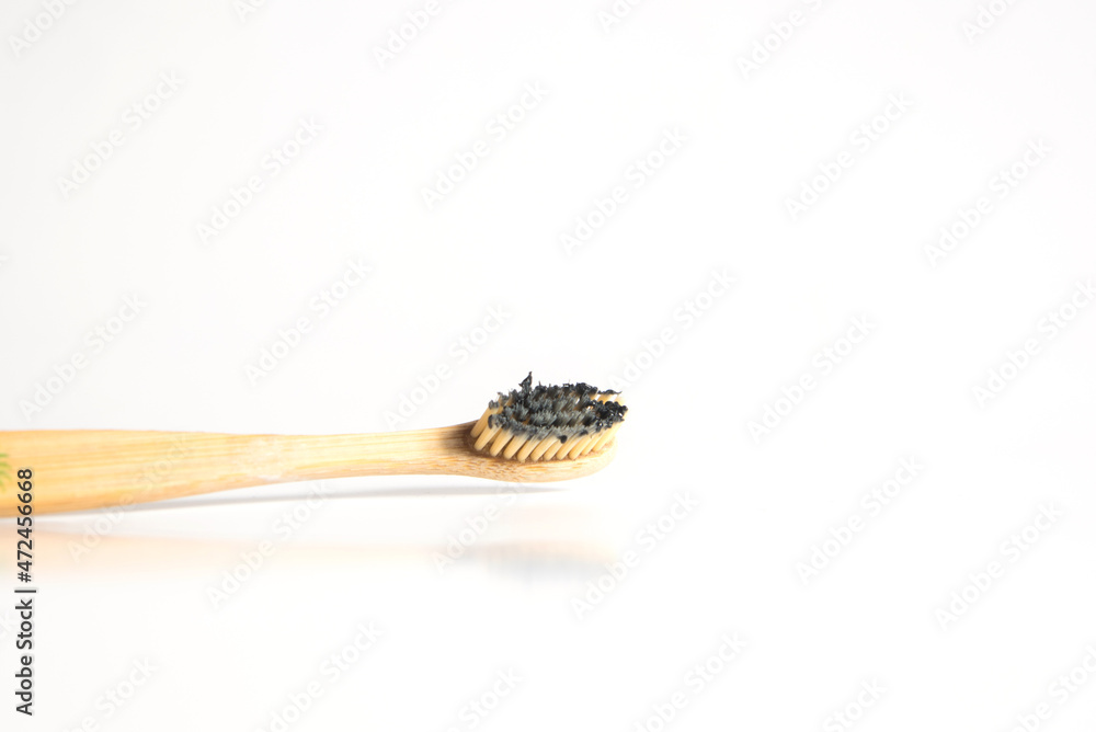 cepillo de dientes de bambú manchado con pasta de dientes negra para blanquear los dientes. Concepto de desperdicio cero.