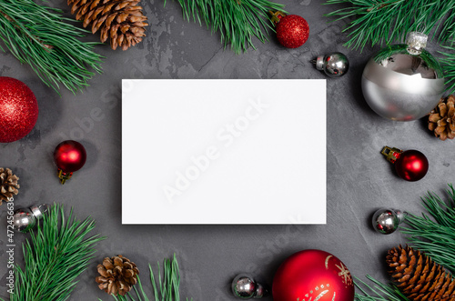 Christmas or New Year greeting card mockup with festive decorations and pine tree branches with cones