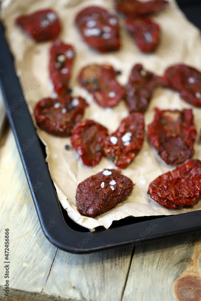 Selective focus. Macro. Sun-dried tomatoes on a baking sheet. Making sun-dried tomatoes.