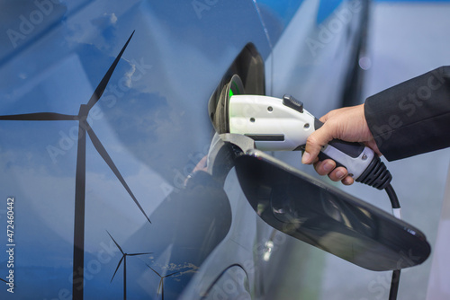 Double exposure of EV charging station for electric car in concept of green sustainable energy produced from renewable resources to supply to charger station in order to reduce CO2 emission .