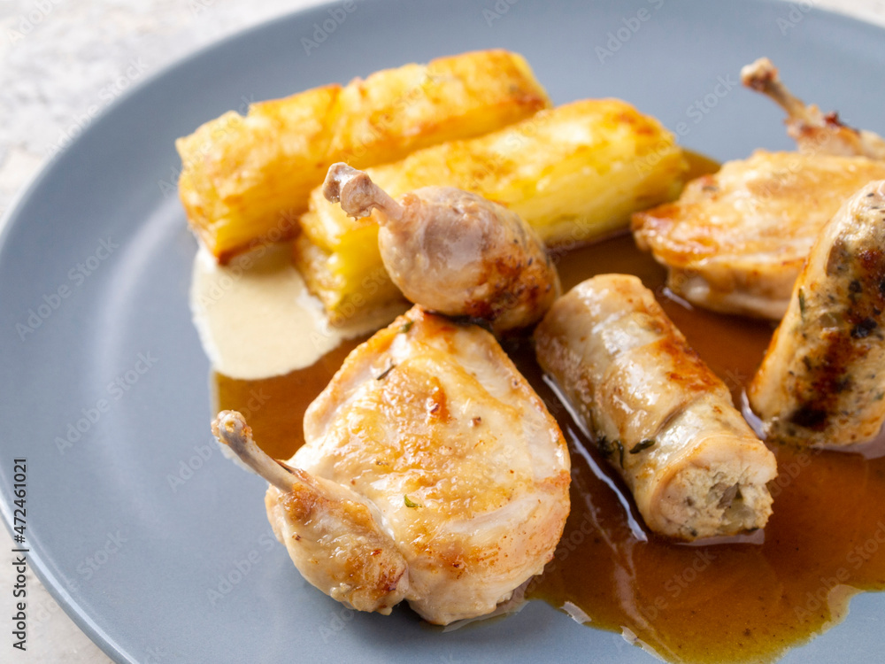 Side view of potato gratin and quail with two sauces.