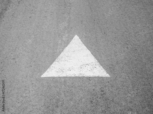 An arrow drawn with white paint on the asphalt. Direction indicator.
