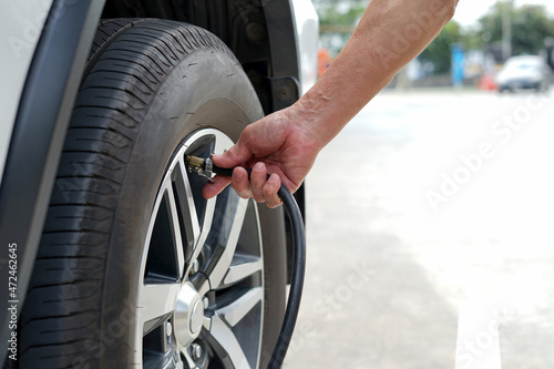 a senior man hand inflate car tire to ensure to drive, concept risk management and safety to use a car © Verin