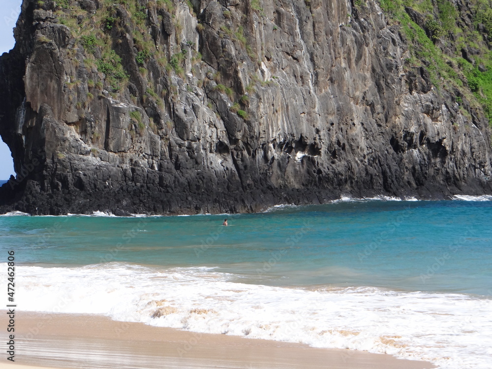 Fernando de Noronha lone surfer sea surfing ocean rock landscape