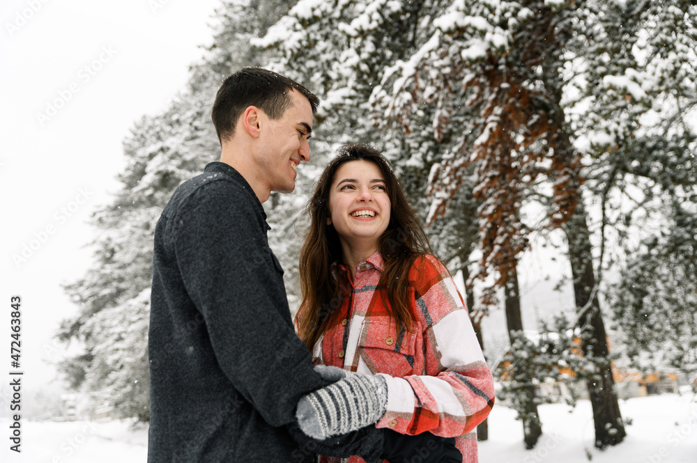 Loving couple in shirt on a winter walk. Man and woman having fun in the frosty forest. Romantic date in winter time.Christmas mood of a young family.Winter lovestory Loving couple in shirt on a winter walk. Man and woman having fun in the frosty forest. Romantic date in winter time.Christmas mood of a young family.Winter lovestory
