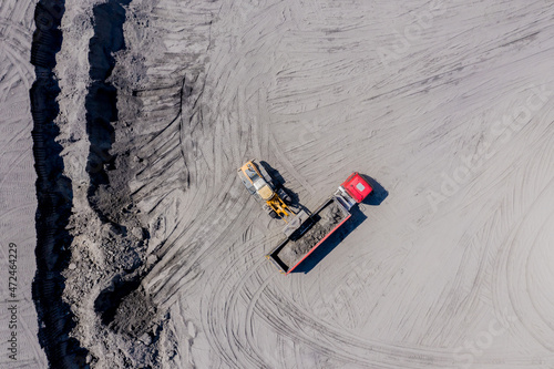 Aerial view of sand quarry with trucks and bulldozers. Heavy bul