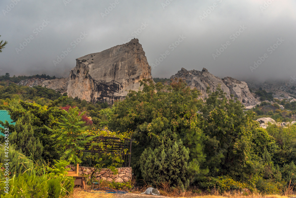 Stony slopes of mountain in dense fog.