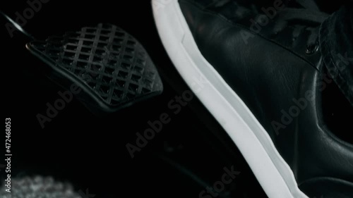 Close up images of man driving car by pushing accelerator and brake pedal with right foot black shoe and black jean pant.