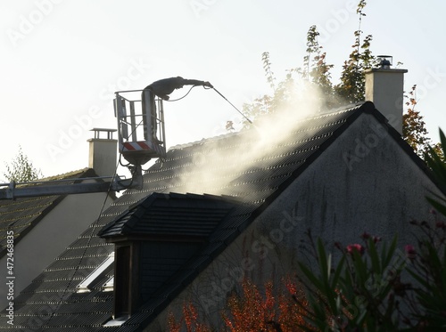 Silhouette of a man washing a roof