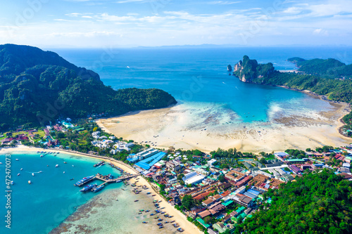 Flying above busy tropical island port filled with boats and fer