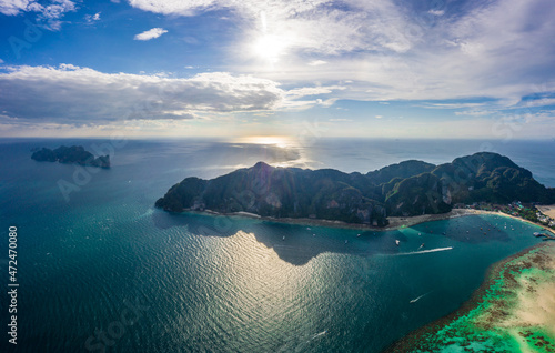 Flying above busy tropical island port filled with boats and fer