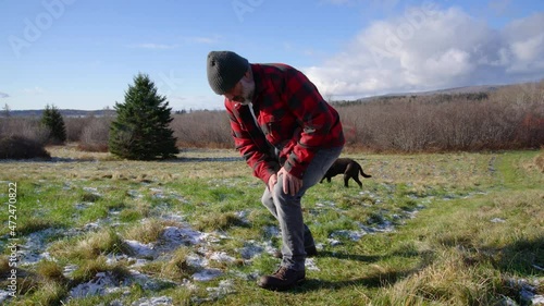 A man experiencing knee pain while out on a walk in the coountryside. photo