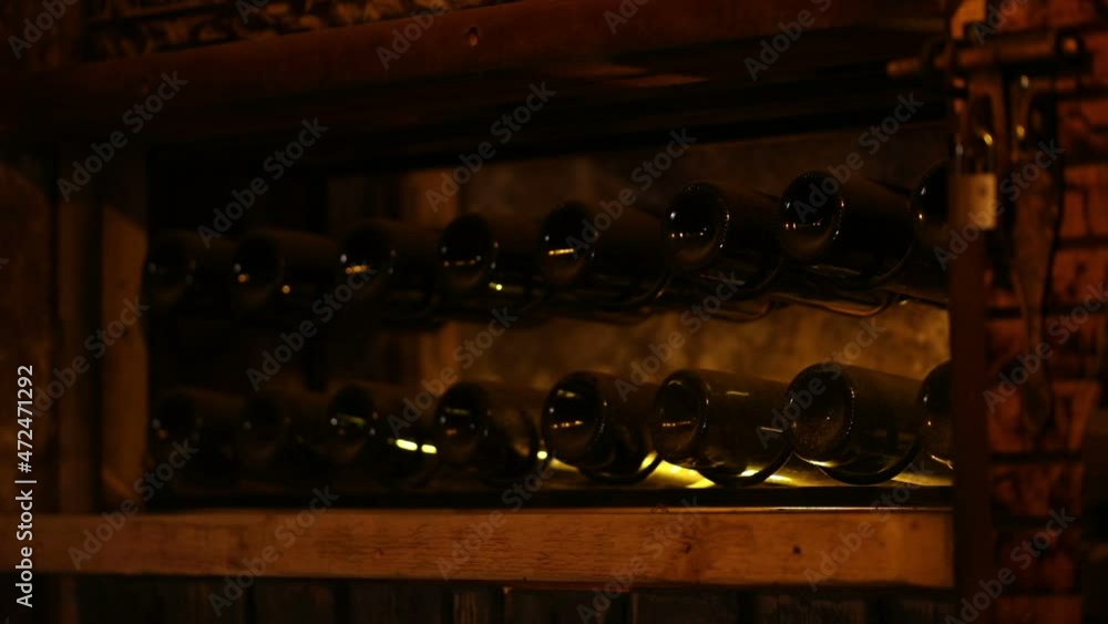 A Wine Cellar. Storage Room for Wine in Bottles and Barrels. Old wine in a dark underground vault. Wooden oak whiskey, wine, cognac, brandy or beer barrels. Bottles on wooden shelves. A Wine Cellar. Storage Room for Wine in Bottles and Barrels. Old wine in a dark underground vault. Wooden oak whiskey, wine, cognac, brandy or beer barrels. Bottles on wooden shelves.