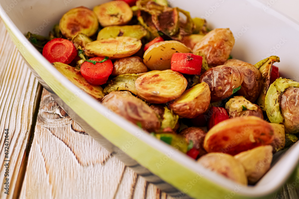 Oven baked vegetables in a baking dish. Vegetable dish close-up. Assorted vegetables roasted with spices, vegan recipe, copy space