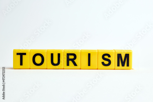 The word tourism consists of individual cubes with letters.