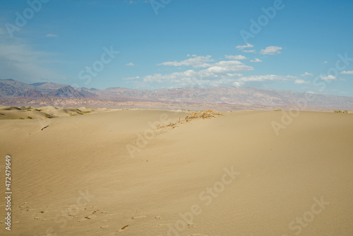 Mesquite Flat Sand Dunes in Death Valley National Park, mountains, and cloudy sky background