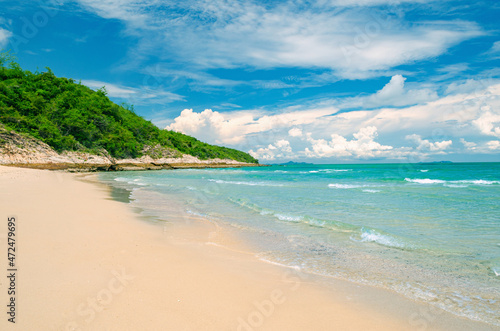Tropical beach with white sand, turquoise ocean and beautiful clouds in the sky.