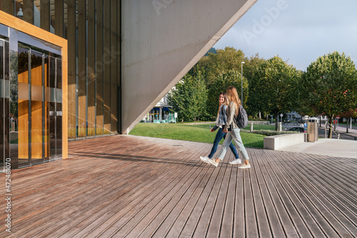 Εκτύπωση καμβά Two college classmates entering the university to attend classes on a sunny day