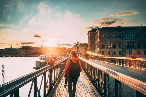 Stockholm, Sweden. Young Caucasian Woman Lady Tourist Traveler Walking On Famous Skeppsholmsbron - Skeppsholm Bridge. Popular Place, Landmark And Destination In Stockholm, Sweden photo