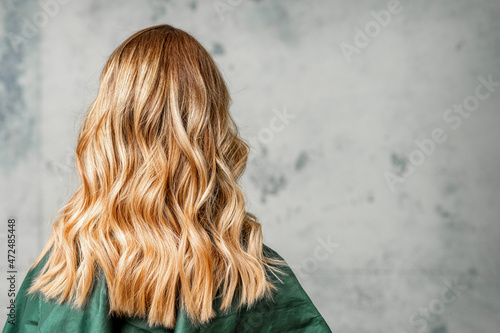 Rear View of a woman with long brown hair against a gray background