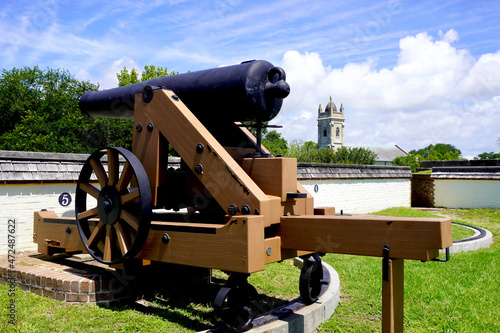 Fort Moultrie National Historic Park in Sullivan's Island, South Carolina. Model 1829 32-pounder gun (cannon)  and Stella Maris Catholic Church. Fort defended Charleston Harbor through many wars. photo
