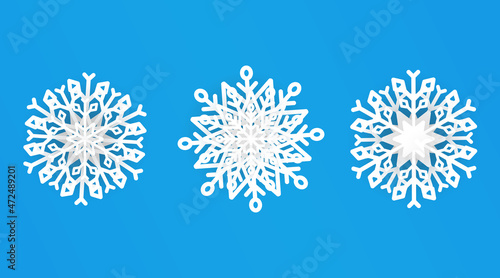 Vector set of white Christmas paper cut 3d snowflakes with shadow on a blue background. New Year and Christmas design elements