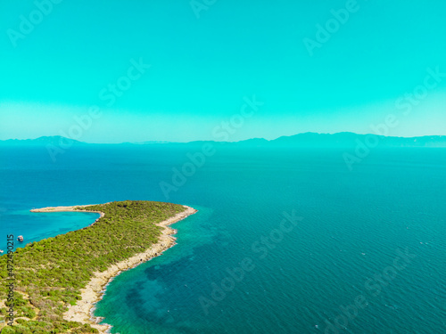 Aerial drone shot of beautiful Maldives island and horizon with mountains. Summer landscape with blue sky and clean sea. © Kaan